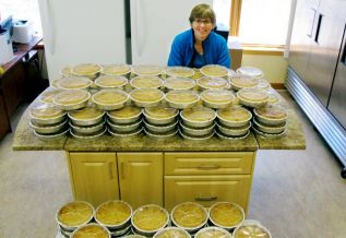 Anne Howes, former owner of the Rising Bun bakeshop, who now works fior Rural Frontenac Community Services, baked 200 apple crumbles for four last week,, with help from a crew of peelers for the community Easter Dinner